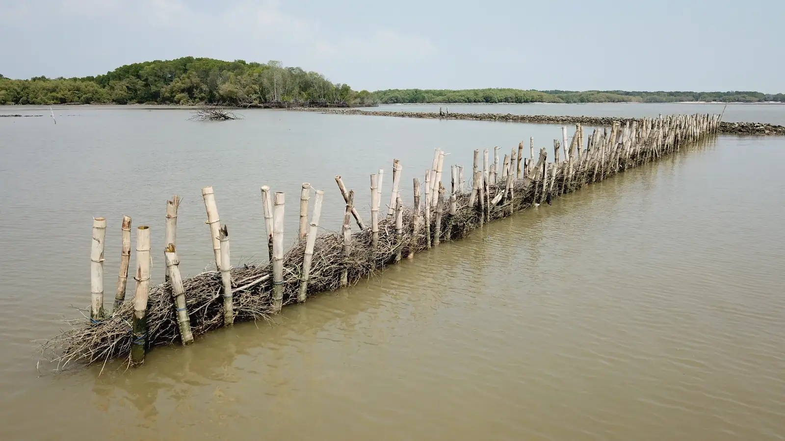 Struktur permeabel dari tiang bambu berisi ranting